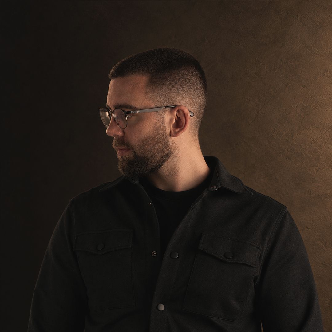 Stefan in profile, wearing glasses and a dark jacket